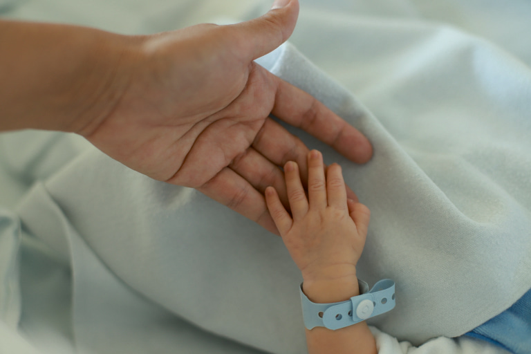 Father holding newborn baby boy, thinking about his name