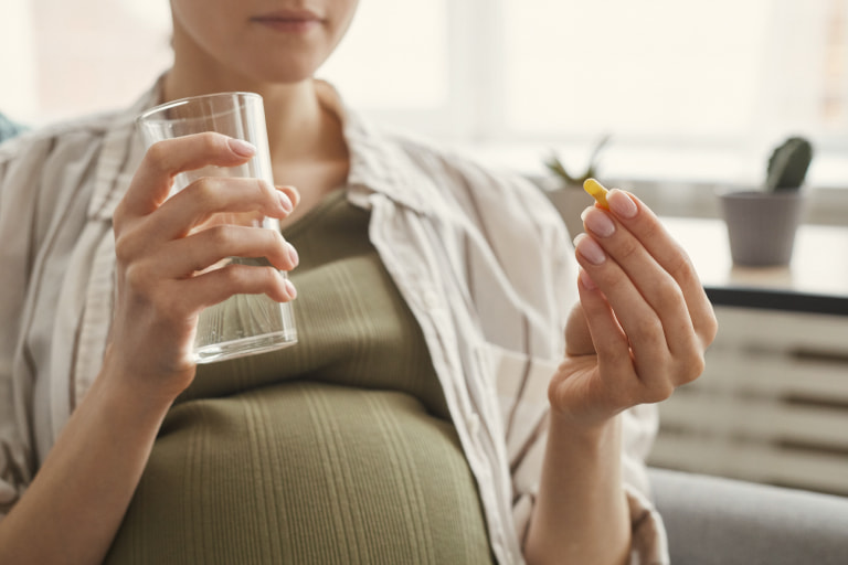 Expecting mom holding prenatal vitamins
