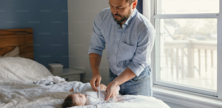 Parent showing how to properly fit a Huggies diaper 