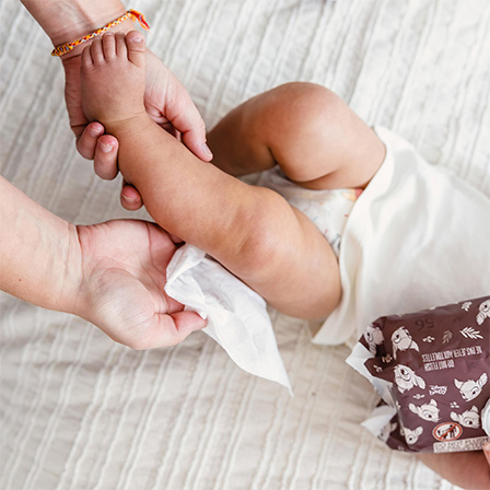 Visualization of parent using Huggies® Calm™ Baby Wipes all over child’s body for a gentle clean