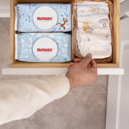 Two packs of Huggies ® Natural Care® Cucumber, Aloe & Vitamin E Baby Wipes with Huggies® Little Snugglers® in a diaper drawer