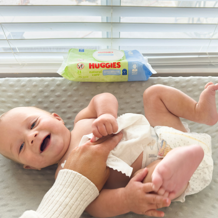 Parents wiping baby with Huggies® Natural Care® Extra Sensitive hypoallergenic wipes 
