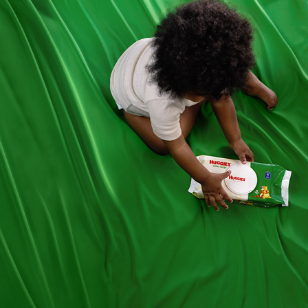 Image of baby grabbing package of Huggies® Extra Large Baby Wipes